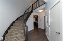 Curved staircase with dark wood-finish handrail and carpeted treads - 2016 Redtail Common, Edmonton, AB  - Indoor Photo Showing Other Room 