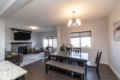 Open-concept living area featuring dark wood-finish flooring - 2016 Redtail Common, Edmonton, AB - Indoor With Fireplace
