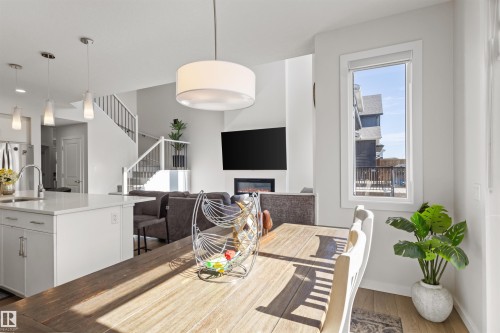 Open-concept living area featuring a central dining space with wood-finish flooring - 1471 Plum Circle Circle, Edmonton, AB - Indoor Photo Showing Dining Room