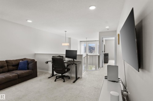 Carpeted loft space featuring recessed lighting and a contemporary pendant light fixture - 1471 Plum Circle Circle, Edmonton, AB - Indoor