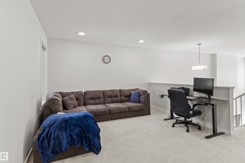 Carpeted loft area featuring a window, recessed lighting, and a contemporary pendant light fixture - 1471 Plum Circle Circle, Edmonton, AB - Indoor