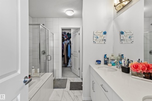 Bathroom featuring a glass-enclosed shower, white tile surround, and a vanity with an undermount sink - 1471 Plum Circle Circle, Edmonton, AB - Indoor Photo Showing Bathroom