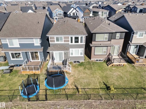 Rear exterior featuring a ground-level deck, sliding glass door, and multiple windows with horizontal blinds - 1471 Plum Circle Circle, Edmonton, AB - Outdoor