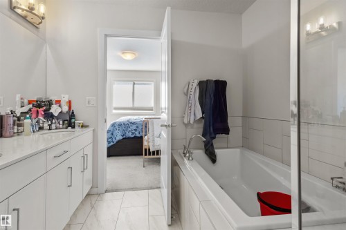 Bathroom featuring a white vanity with integrated sink, chrome faucet, and overhead three-bulb vanity light - 1471 Plum Circle Circle, Edmonton, AB - Indoor Photo Showing Bathroom