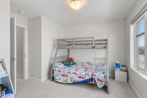 Bright room featuring a large window, neutral wall paint, and light-colored carpet flooring - 1471 Plum Circle Circle, Edmonton, AB - Indoor Photo Showing Bedroom