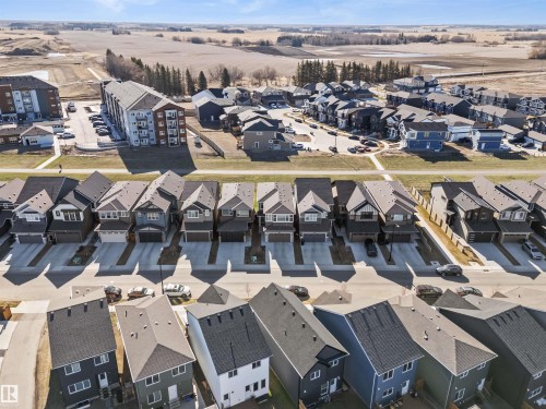 New residential development featuring modern detached homes with attached garages, multi-unit apartment buildings, and undeveloped land - 1471 Plum Circle Circle, Edmonton, AB - Outdoor With View