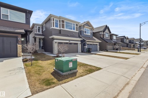 Contemporary multi-level residence featuring dark siding, stone accents, and a dual-panel garage door - 1471 Plum Circle Circle, Edmonton, AB - Outdoor With Facade