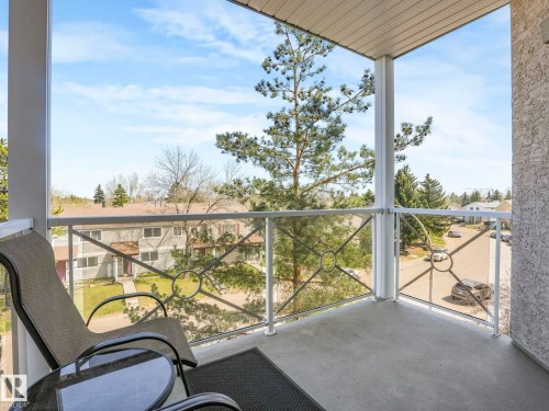 Private balcony with concrete flooring, white railings, and clear panel inserts featuring decorative metalwork - 317 2420 108 Street, Edmonton, AB - Outdoor With Balcony With Exterior