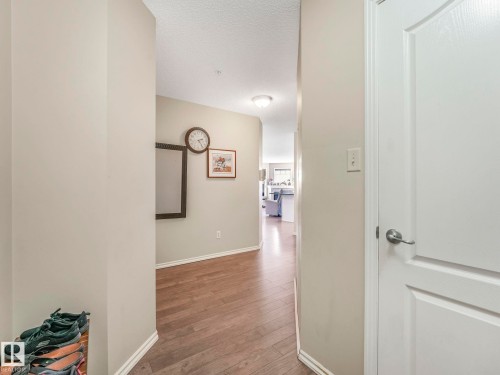 Hallway featuring wood-finish flooring, light-toned wall paint, and white trim - 317 2420 108 Street, Edmonton, AB - Indoor Photo Showing Other Room