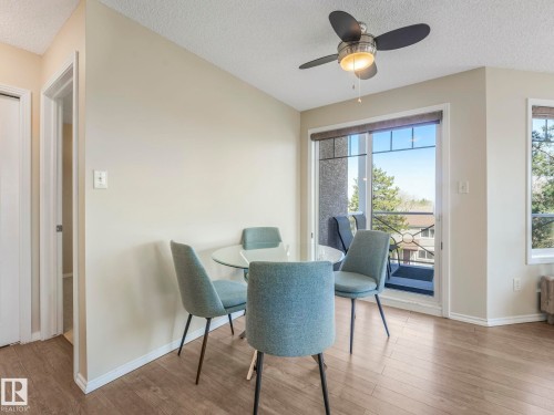 Bright interior space with wood-finish flooring, a ceiling fan with integrated lighting, and a sliding glass door providing balcony access - 317 2420 108 Street, Edmonton, AB - Indoor Photo Showing Dining Room