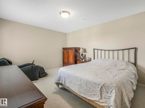 Spacious bedroom featuring light neutral wall paint and plush carpet flooring - 317 2420 108 Street, Edmonton, AB - Indoor Photo Showing Bedroom