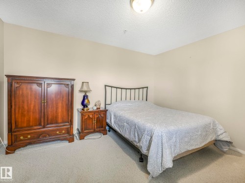 Neutral-toned walls complement the textured ceiling and carpeted flooring - 317 2420 108 Street, Edmonton, AB - Indoor Photo Showing Bedroom