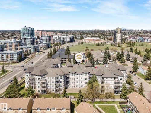 Multi-story residential building featuring light-toned exterior siding, multiple private balconies, and complex rooflines with circular turret elements - 317 2420 108 Street, Edmonton, AB - Outdoor With View
