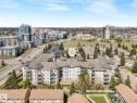 Multi-story residential building featuring light-toned exterior siding, multiple private balconies, and complex rooflines with circular turret elements - 317 2420 108 Street, Edmonton, AB  - Outdoor With View 