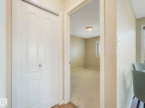 White bi-fold closet doors with panel detailing - 317 2420 108 Street, Edmonton, AB - Indoor Photo Showing Other Room