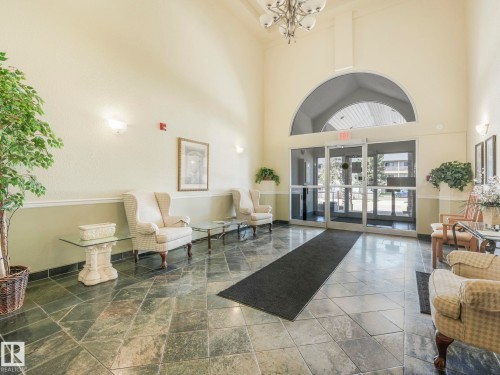 Spacious foyer featuring high ceilings and a central chandelier - 317 2420 108 Street, Edmonton, AB - Indoor
