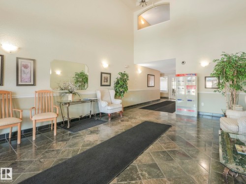 Spacious entryway featuring slate tile flooring, two-tone wall paint, and overhead lighting - 317 2420 108 Street, Edmonton, AB - Indoor Photo Showing Other Room