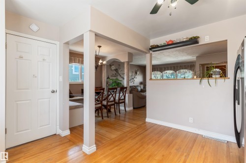 Entryway with hardwood flooring, a six-panel door, and a partially open floor plan - 10803 52 Street, Edmonton, AB - Indoor Photo Showing Other Room