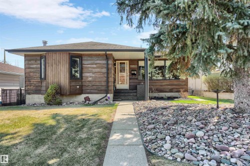 Ranch-style exterior with natural wood siding and a covered entry - 10803 52 Street, Edmonton, AB - Outdoor