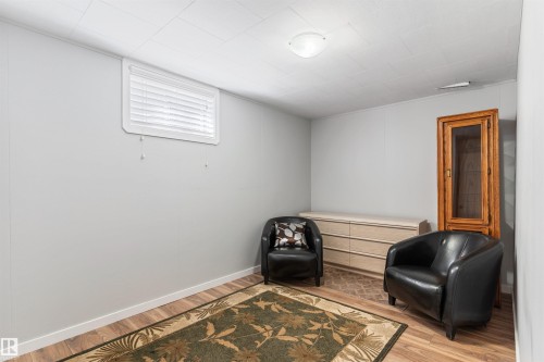Recessed window with white blinds, wood-finish flooring, light gray walls, and a ceiling-mounted flush light fixture - 10803 52 Street, Edmonton, AB - Indoor Photo Showing Other Room