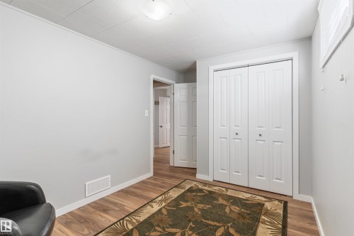 Room featuring wood-finish flooring, light gray wall paint, and white baseboards - 10803 52 Street, Edmonton, AB - Indoor