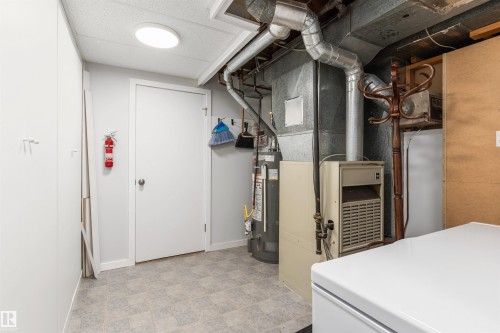 Utility room featuring exposed ductwork, a water heater, and a furnace unit - 10803 52 Street, Edmonton, AB - Indoor Photo Showing Basement