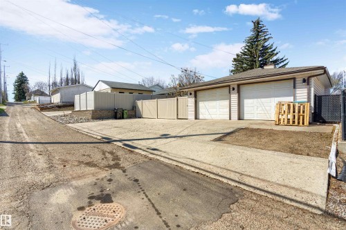 Two-car garage with white paneled doors and exterior wall sconces - 10803 52 Street, Edmonton, AB - Outdoor