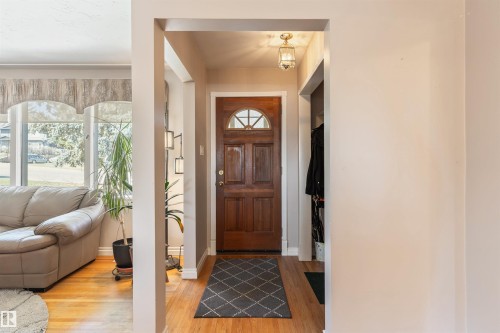 Hardwood flooring extends from the entryway throughout the visible areas - 10803 52 Street, Edmonton, AB - Indoor Photo Showing Other Room