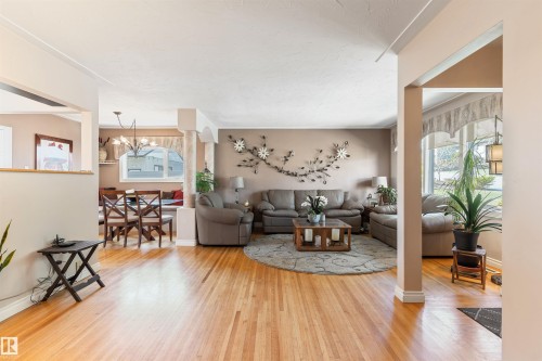 Spacious living area featuring warm wood-finish flooring - 10803 52 Street, Edmonton, AB - Indoor Photo Showing Living Room