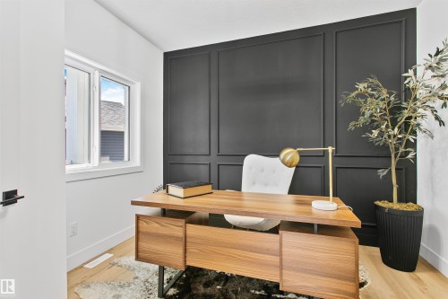 Room featuring a paneled accent wall, light wood-finish flooring, and a white framed window - 34 Harley Way, Spruce Grove, AB - Indoor Photo Showing Office
