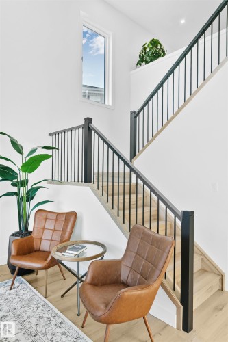 Staircase featuring wood-finish treads, black metal balusters, and a contemporary white window - 34 Harley Way, Spruce Grove, AB - Indoor Photo Showing Other Room