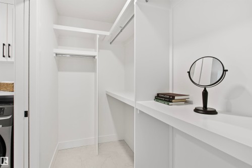 White built-in closet system featuring multiple shelving units and hanging rods - 34 Harley Way, Spruce Grove, AB - Indoor With Storage