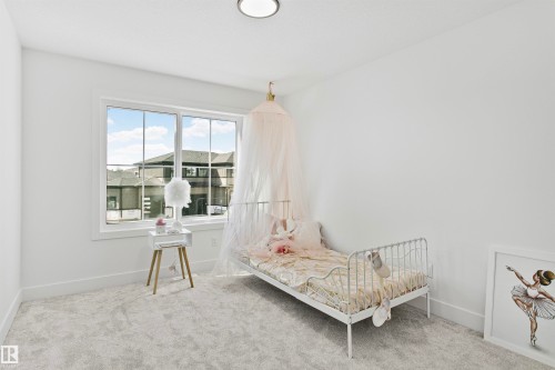 Bright room featuring neutral carpeting, white walls, and a large window with white trim - 34 Harley Way, Spruce Grove, AB - Indoor Photo Showing Bedroom