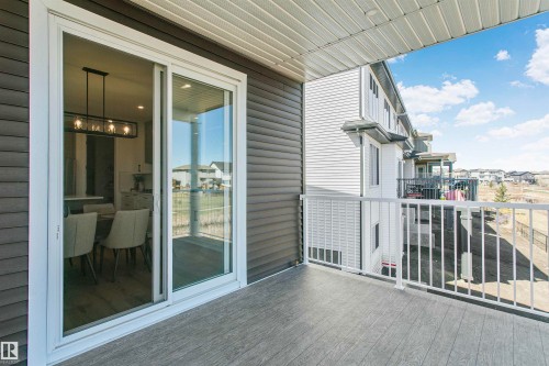 Private outdoor deck featuring wood-finish composite flooring and white metal railings - 34 Harley Way, Spruce Grove, AB - Outdoor With Exterior