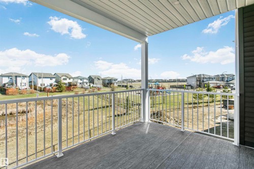 Covered exterior balcony with composite decking and white metal railings - 34 Harley Way, Spruce Grove, AB - Outdoor With View With Exterior