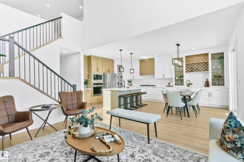 Two-story living area featuring a modern staircase with dark balusters, light wood-finish flooring, and recessed lighting - 34 Harley Way, Spruce Grove, AB - Indoor Photo Showing Living Room