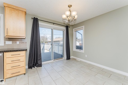 Sliding glass doors opening to a wood-finish deck - 8530 76 Avenue, Edmonton, AB - Indoor