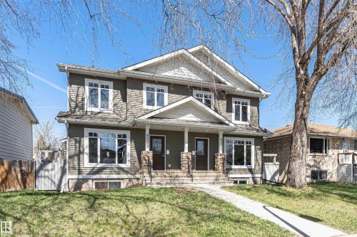 Duplex with two distinct entrances featuring a neutral siding facade and white trim - 8530 76 Avenue, Edmonton, AB - Outdoor With Deck Patio Veranda With Facade