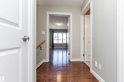 Hallway featuring wood-finish flooring, light gray wall paint, and white trim - 8530 76 Avenue, Edmonton, AB - Indoor Photo Showing Other Room