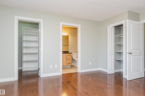 Rich wood-finish flooring complements light-toned walls - 8530 76 Avenue, Edmonton, AB - Indoor Photo Showing Other Room