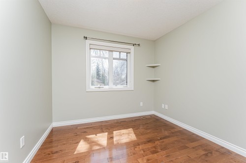 Bright room featuring wood-finish flooring and a white trimmed window - 8530 76 Avenue, Edmonton, AB - Indoor Photo Showing Other Room