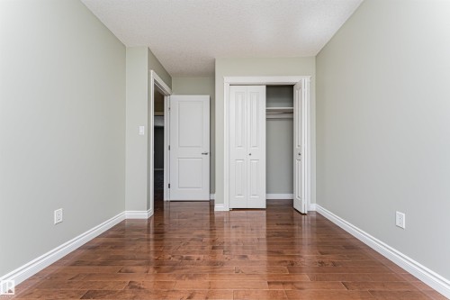 Room featuring wood-finish flooring, light-toned wall paint, and white trim molding - 8530 76 Avenue, Edmonton, AB - Indoor Photo Showing Other Room