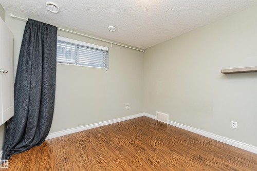 Room with wood-finish flooring, light green walls, and white baseboards - 8530 76 Avenue, Edmonton, AB - Indoor Photo Showing Other Room