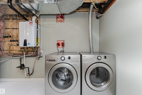 Dedicated utility area featuring a tankless water heater and exposed PEX plumbing - 8530 76 Avenue, Edmonton, AB - Indoor Photo Showing Laundry Room