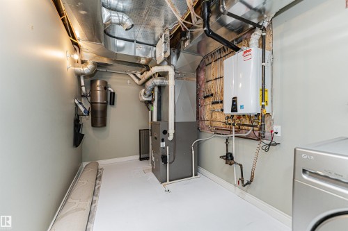 Utility space featuring a water heater, central vacuum system, furnace, and exposed ductwork - 8530 76 Avenue, Edmonton, AB - Indoor Photo Showing Basement