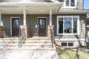 Front facade featuring horizontal siding, a covered porch with stone-clad columns, and a concrete entryway with metal railings - 8530 76 Avenue, Edmonton, AB  - Outdoor With Deck Patio Veranda With Facade 