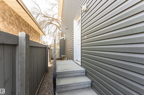 Gray horizontal siding exterior with a white entry door - 8530 76 Avenue, Edmonton, AB - Outdoor With Exterior