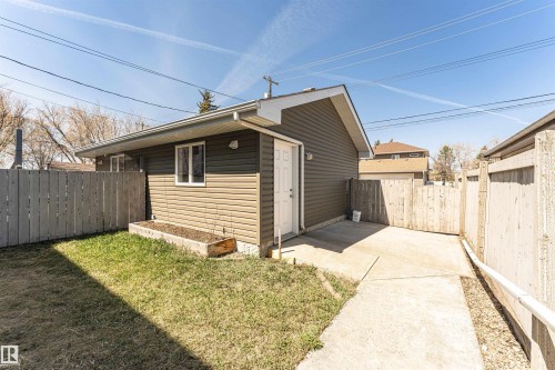 Detached garage featuring dual-tone siding, multiple windows, and a side access door - 8530 76 Avenue, Edmonton, AB - Outdoor With Exterior