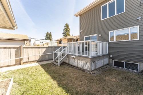 Gray horizontal siding exterior with multiple windows and a white-railed deck featuring stairs - 8530 76 Avenue, Edmonton, AB - Outdoor With Deck Patio Veranda With Exterior