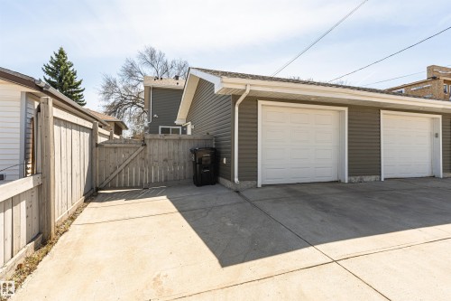 Detached garage with two white overhead doors and gray horizontal siding - 8530 76 Avenue, Edmonton, AB - Outdoor With Exterior